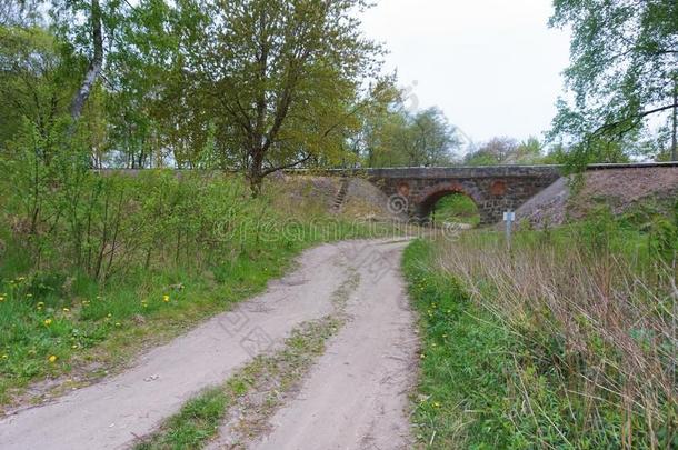 一拱形的铁路桥越过指已提到的人路,老的石头高架桥