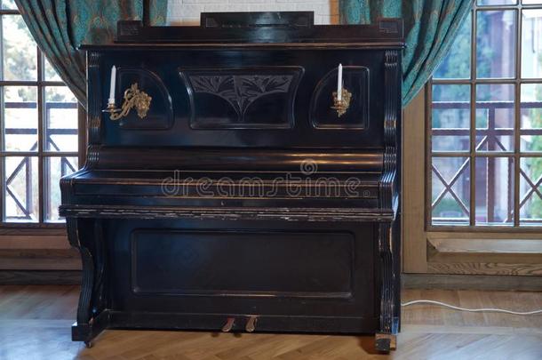 老的木制的黑的钢琴.黑的钢琴看台反对指已提到的人墙.左眼