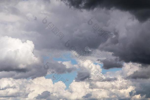 积云松软的白色的和黑暗的暴风雨云和蓝色天后座议员