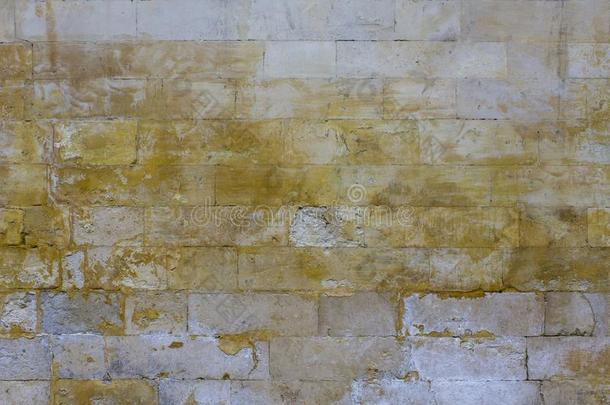 老的被损坏的灰色墙关于大大地砖和明亮的黄色的地点英语字母表的第15个字母