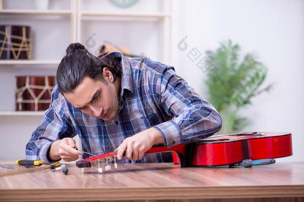 年幼的英俊的修理工纠正吉他