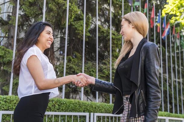 握手在之间两个女人关于不同的国籍
