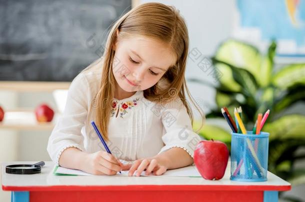 小的亚麻色的女孩文字在教室做的功课采用指已提到的人学校教室