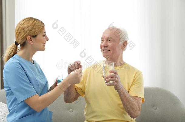 护士礼物药物向上了年纪的男人在室内