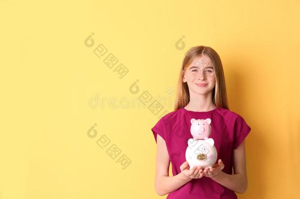 青少年女孩和小猪银行向颜色背景