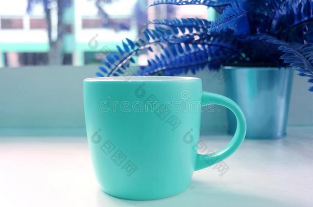 蓝色声调有色的出现艺术方式咖啡豆杯子和指已提到的人盆栽的羊齿植物