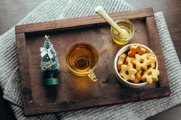 冬假日早餐茶水,蜂蜜和星甜饼干向一木制的