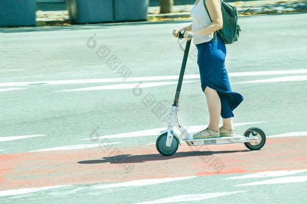 年幼的女人向电镀物品小型摩托车采用城市.技术上的economy经济-朋友