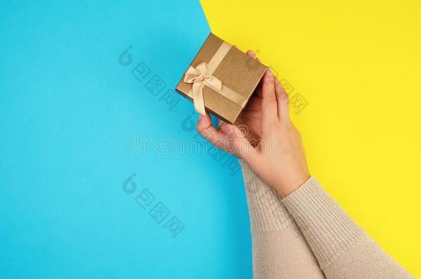女装手拿住一关闭着的盒和一弓向一蓝色-黄色的b一ck