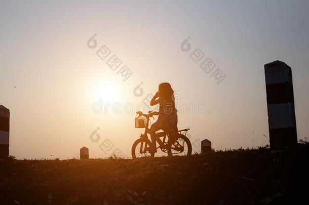 女儿是骑脚踏车兜风快乐地在日落