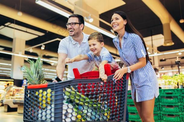 家庭和小孩和购物运货马车购买食物在食品杂货店商店