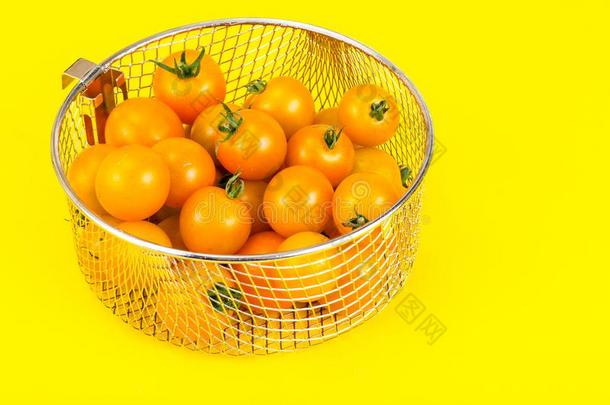 黄色的成熟的小的番茄采用金属篮