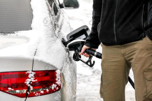 男人装满他的雪大量的柴油机汽车气体油箱在指已提到的人燃料pop-upmechanism弹出机械装置