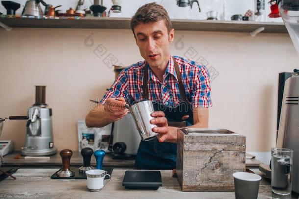 手滴下咖啡豆.咖啡馆准备咖啡的员工传布咖啡豆从银茶壶
