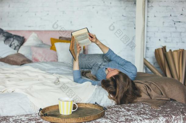 年幼的女人阅读书向床采用阁<strong>楼房</strong>间,慢的生活