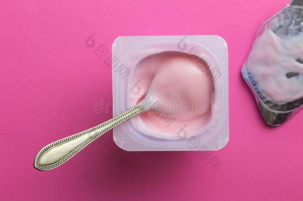 草莓粉红色的酸奶采用塑料制品杯子和勺和箔盖子是（be的三单形式