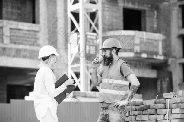 女人工程师和野蛮的建设者传达建筑物地点