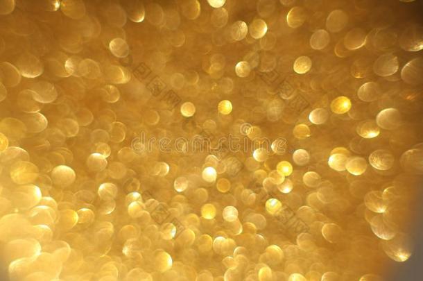 金色的闪烁圣诞节抽象的焦外成像背景.变模糊圆材