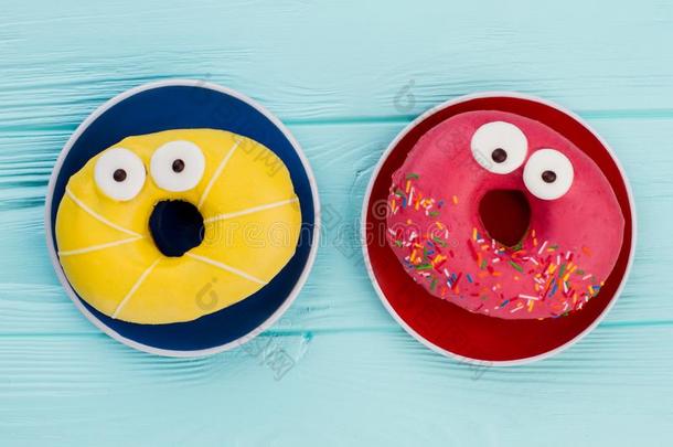 两个盘子和有趣的油炸圈饼向颜色背景.