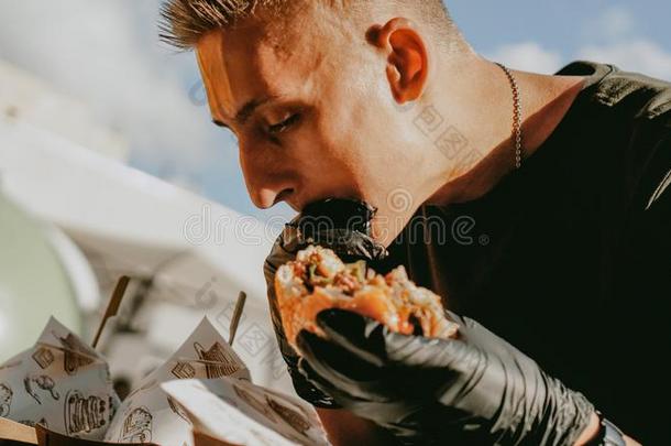 男人强制执行户外的大街食物节日,啤酒和汉堡包事件