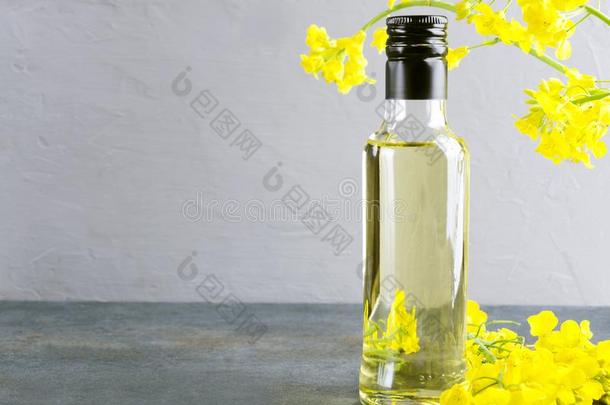 玻璃瓶子关于油使关于油菜籽花和盛开的加拿大油菜