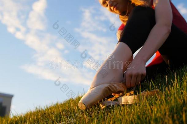 年幼的女人放向她足尖站立的姿式鞋子-一次向指已提到的人绿色的草