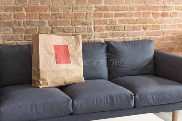 空白的纸赠<strong>品</strong>或<strong>购</strong>物袋起立向蓝色现代的沙发