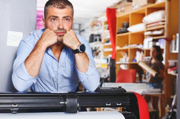 肖像工作的男人在打印机工作室