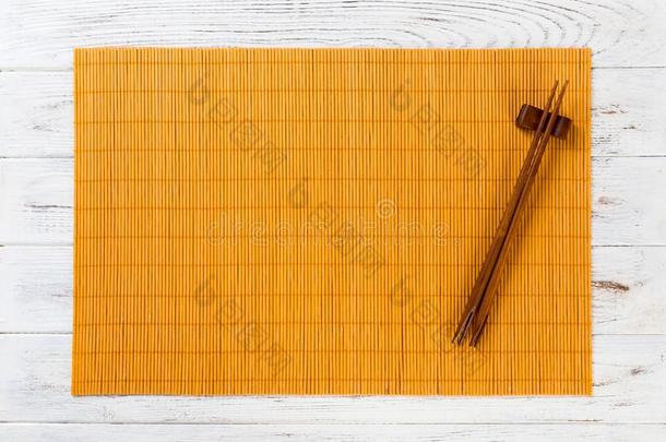 两个寿司<strong>筷子</strong>和空的黄色的竹子席子或木材<strong>盘子</strong>