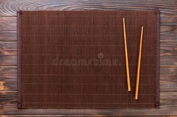 两个寿司筷子和空的竹子席子或木材盘子向木材