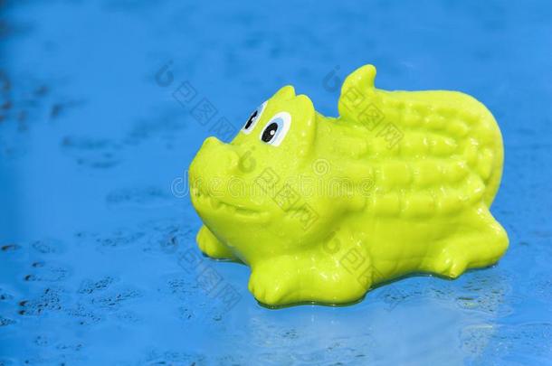 绿色的<strong>鳄鱼玩具</strong>是（be的三单形式向湿的蓝色背景