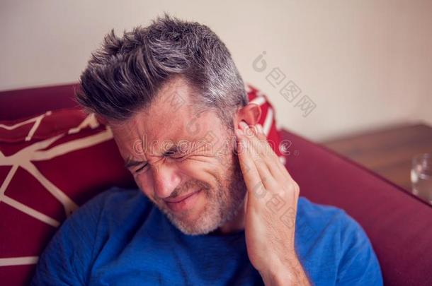 男人摸索强的耳朵痛苦.人,卫生保健和医学自负