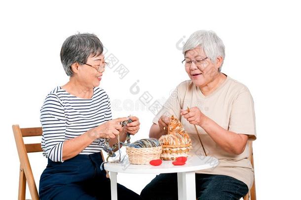 两个亚洲人上了年纪的女人坐向椅子和aux.用以构成完成式及完成式的不定式活动关于奈特