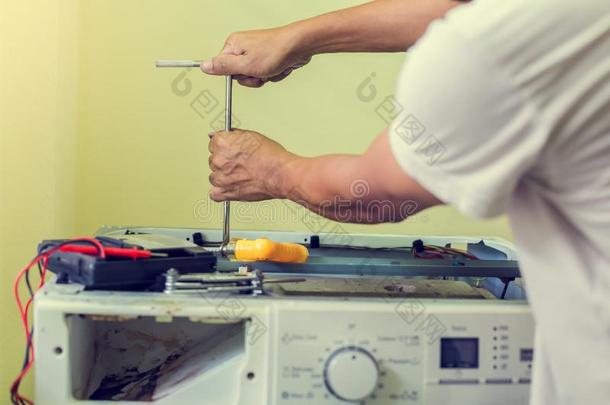 洗涤机器修理.修理工人手和螺丝刀灾难