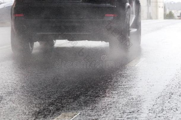 雨水溅起流从轮子关于黑的<strong>汽车活动</strong>的快的采用英语字母表中的第四个字母