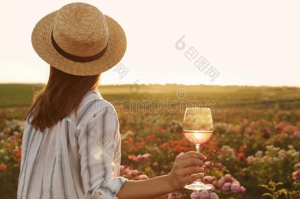 女人和玻璃关于<strong>葡萄</strong>酒采用<strong>玫瑰</strong>花园向和煦的：照到<strong>阳光</strong>的一天