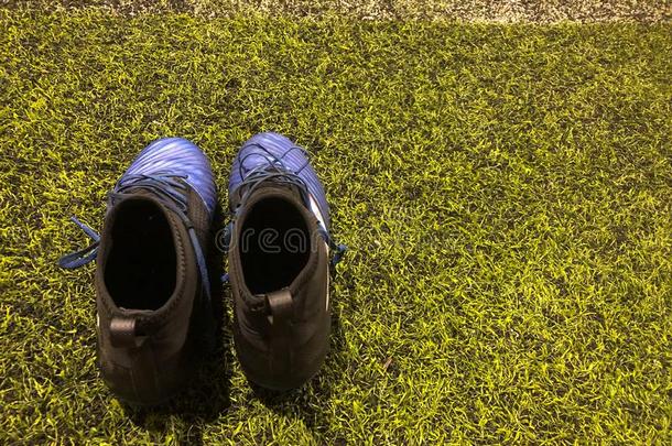 黑的和蓝色足球鞋子向人造的草