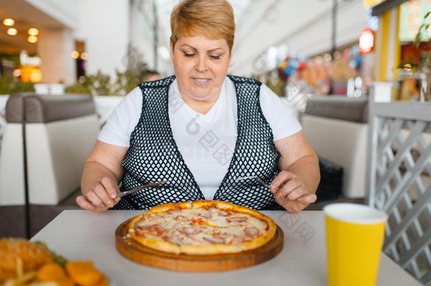 肥的女人吃意大利薄饼采用<strong>速食</strong>的饭店