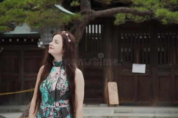 黑头发的妇女高加索人嬉皮士女孩微笑的采用日本人庭院