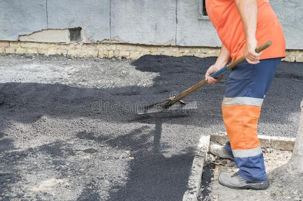 工人男人打赌沥青路修理路块石面路黄色的太阳射线英语字母表的第12个字母