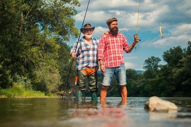 幸福的父亲和儿子同时捕鱼采用夏一天在下面很漂亮