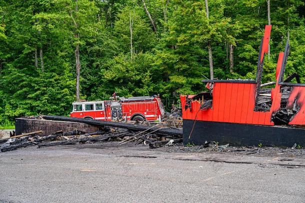 大的红色的火货车在近处指已提到的人烧坏的出局商店,火使熄灭.