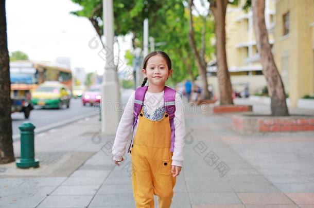 幸福的亚洲人小孩女孩步行和学生肩膀<strong>书包</strong>.