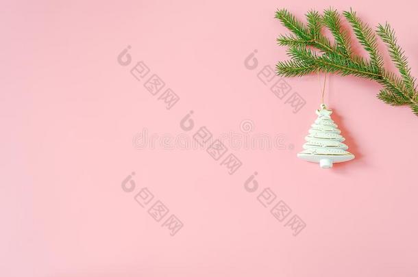 白色的圣诞节装饰树玩具向冷杉树枝向粉红色的后面