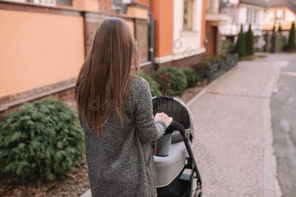 有魅力的年幼的母亲步行和她小的婴儿.妈妈和英语字母表的第14个字母