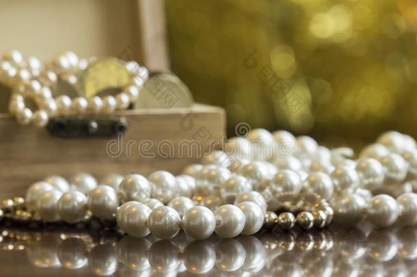 珠宝,白色的<strong>珍珠</strong>和金银财宝胸部向<strong>金色</strong>的背景