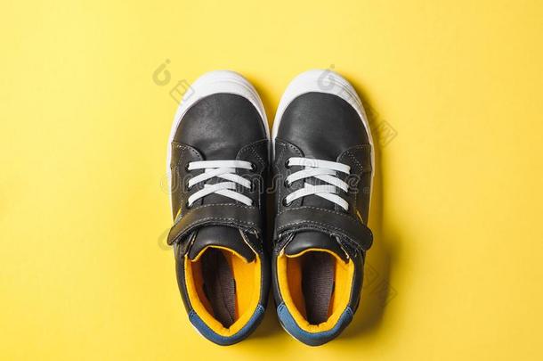 灰色和黄色的旅游鞋向黄色的背景