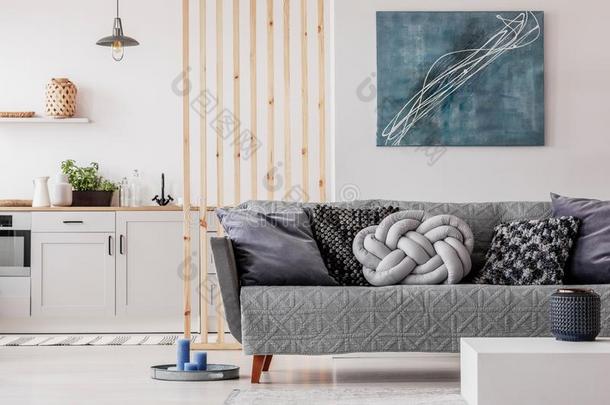 时髦的结光灰色的枕头向舒适的斯堪的纳维亚的长沙发椅