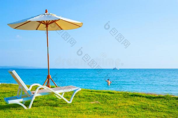 海滩椅子和海滩伞是向指已提到的人草地在指已提到的人海滩.Sweden瑞典