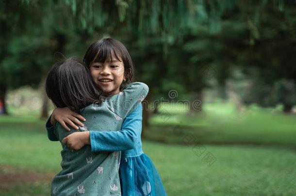两个小的女儿热烈地拥抱每别的原谅